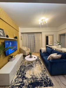 un soggiorno con un divano blu e una TV di Elite Residence a Nairobi