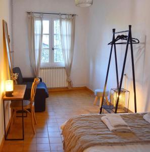 een kamer met een bed, een tafel en een bureau bij La Source in Oppedette