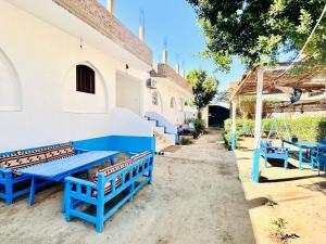 a group of blue benches sitting next to a building at Golden Rose Guesthouse in Luxor