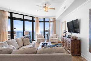 a living room with a couch and a flat screen tv at The Oasis at Orange Beach 2208 (Phoenix West II) in Orange Beach
