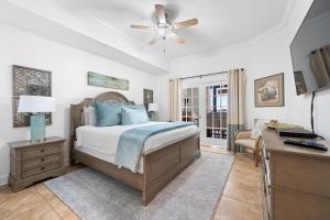 a bedroom with a bed with a ceiling fan and a desk at The Oasis at Orange Beach 2208 (Phoenix West II) in Orange Beach +94 photos
