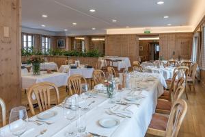a dining room with white tables and chairs at Hotel Post in Bivio