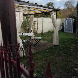a backyard with a wooden deck with a pergola at Le vieux pré de la motte in Villers-sur-Mer