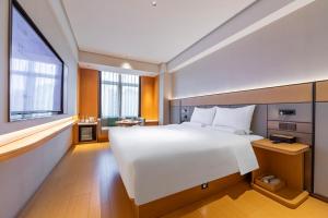 Una cama o camas en una habitación de JI Hotel Shanghai Dishui Lake Subway Station 73 fotos más