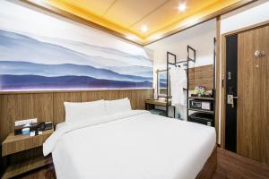 a bedroom with a bed and a painting on the wall at A25 Premium Hotel - 21 Nghia Tan in Hanoi