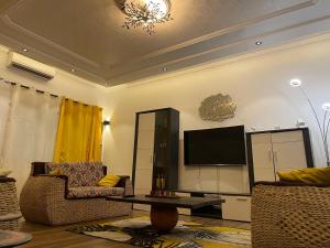 a living room with two chairs and a flat screen tv at Villa SESSI in Abomey-Calavi +5 photos