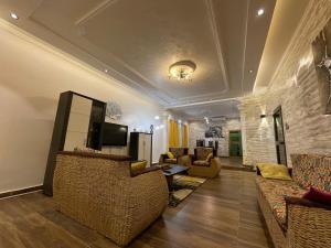 a living room with couches and a tv on a wall at Villa SESSI in Abomey-Calavi