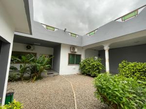 a white house with a courtyard with plants at Villa SESSI in Abomey-Calavi