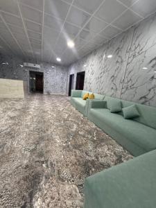a living room with a couch and a marble wall at Evan Rest House in Salalah +1 photo
