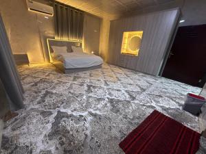 a bedroom with a bed in a room with ailed floor at Evan Rest House in Salalah