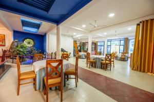 a dining room with tables and chairs and blue ceilings at Royal Sea Wind in Matara