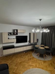 a living room with a dining table and a television at Central Apartment KM 0 in Craiova