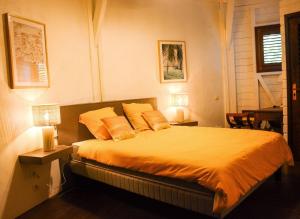 - une chambre avec un lit doté de draps et d'oreillers orange dans l'établissement Casa Alba - 1 bedroom house - sea view, garden & swimming pool, à Oyster Pond