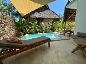 a swimming pool in a villa with a bed and a table at Boutique Villa Unaweza in Matemwe
