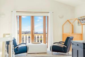 Zimmer mit Stühlen, einem Tisch und einem Balkon in der Unterkunft Jamanota Villa 4BR Mansion with Infinity Pool in Noord + 44 Fotos