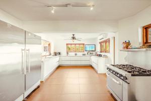 eine Küche mit weißen Schränken und einem Herd in der Unterkunft Jamanota Villa 4BR Mansion with Infinity Pool in Noord