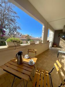 un tavolo con sedie e un balcone con bollitore per il tè di Apparthotel Angela ad Alezio