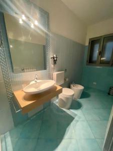 un bagno con lavandino, WC e specchio di Apparthotel Angela ad Alezio