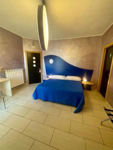 una camera da letto con un letto blu in una stanza di Apparthotel Angela ad Alezio