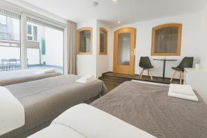 a bedroom with two beds and a table and chairs at Old Town Apartments in Düsseldorf