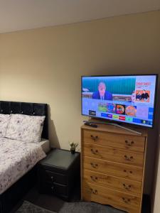 a bedroom with a flat screen tv on a dresser at Large double walking distance to NewCross Hospital in Fallings Park +5 photos