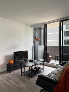 Waterfront High Rise 5 Beds 2 Car Parks في سيدني: غرفة معيشة مع أريكة وطاولة