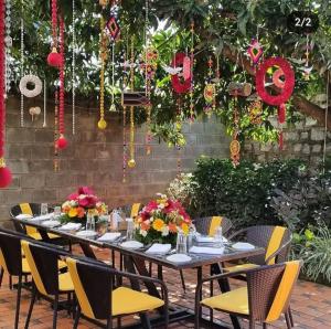 a long table with chairs and flowers on it at Genesis Retreat in Dāvangere