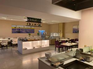 a restaurant with tables and chairs and a buffet at Lavande Hotel Guangzhou Panyu Chimelong Xiajiao Metro Station Branch in Guangzhou