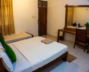 une chambre avec deux lits, un miroir et un bureau dans l'établissement Villa by Wilpattu Nature Resort, à Murandanveli