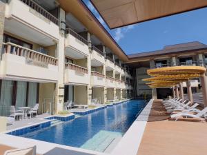 an image of a hotel pool with chairs and umbrellas at Coron Westown Resort in Coron
