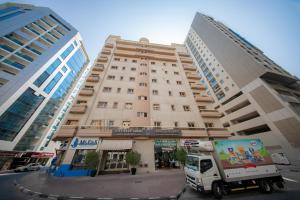 a white truck parked in front of a building at City Stay Grand Hotel Apartments - Al Barsha in Dubai
