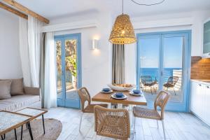 a living room with a table and chairs and the ocean at Yploui Suites in Karpathos Town