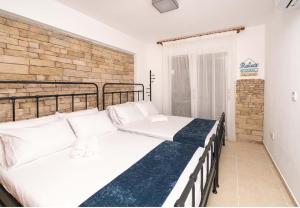 une chambre avec deux lits et un mur de briques dans l'établissement Stella's Little Island Gem, à Paralímni