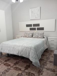 a bedroom with a bed with a gray comforter at El descanso soberano in Ossa de Montiel