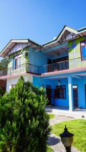 a blue building with a tree in front of it at Summer Guest House in Chauntrā