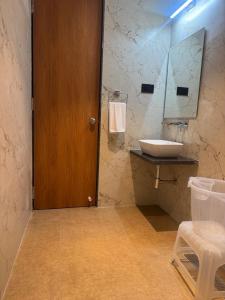 a bathroom with a sink and a wooden door at Regenta Z Mahabaleshwar in Mahabaleshwar +17 photos
