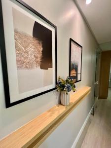 a vase with flowers on a shelf in a hallway at Bahamas 357 - Com Garagem in Águas Claras