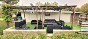 a pergola with chairs and tables in a yard at grains de soleil in Castelnau-dʼEstrétefonds +4 photos