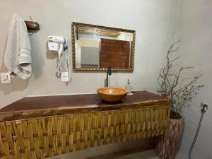 ein Badezimmer mit einem Waschbecken und einem Spiegel in der Unterkunft Recanto do Calango in Lajeado + 14 Fotos