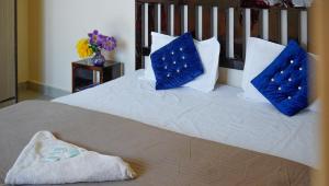 a bed with blue and white pillows on it at Summer Guest House in Chauntrā