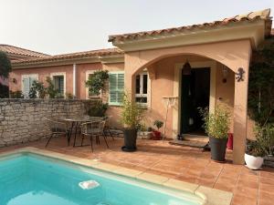 a house with a pool and a table and chairs at vue sur le golfe de Saint Florent in Saint-Florent