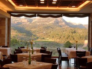 a restaurant with tables and chairs and a large window at Hotel & Spa Can Josep in Bot