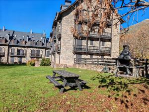 een picknicktafel in het gras voor een gebouw bij Chimenea y piscina-Dúplex perfecto para todo el año - Herbasabina 4 in Pla de l'Ermita