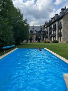 een persoon die zwemt in een groot blauw zwembad bij Chimenea y piscina-Dúplex perfecto para todo el año - Herbasabina 4 in Pla de l'Ermita