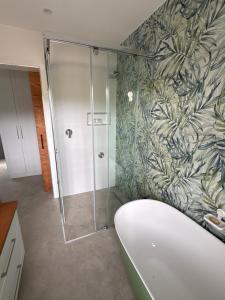 een badkamer met een douche met een glazen deur bij Topiary Lux Studio 16! in Herolds Bay +52 foto's