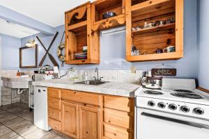 德卢斯Great Lakes Suite InnOnGitcheGumee的厨房配有木制橱柜和白色炉灶烤箱。 更多12张照片