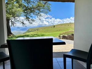 a table and chairs with a view of a field at Windmill Farm in Bergville