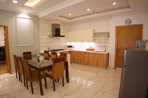 a kitchen with a table and chairs and a kitchen with a counter at Fior Residence 2BHK in Rawalpindi