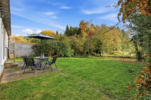 un patio con tavolo, sedie e ombrellone di Seven Space - Church Close a Coltishall