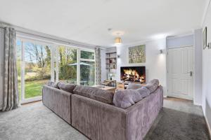 un soggiorno con divano e camino di Seven Space - Church Close a Coltishall